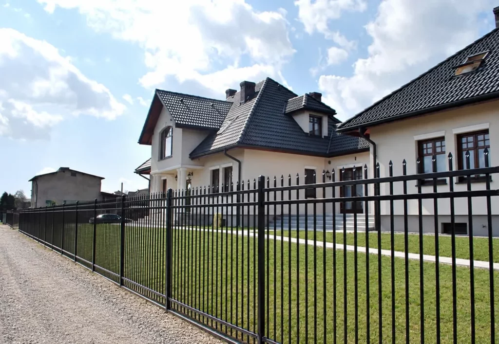 Czarne ogrodzenie z pionowym wypełnieniem przy posesji